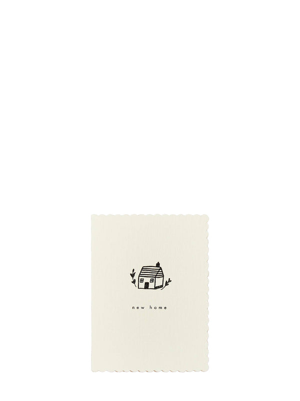 An off-white rectangular card with scalloped edges, featuring a small black line drawing of a house and the text 'new home' centered below it, set against a solid white background.
