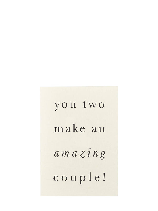 A cream-colored greeting card with black serif text that reads 'you two make an amazing couple!' on a solid white background.