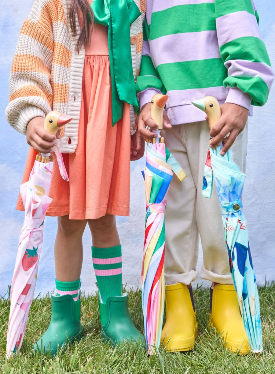 Two children holding colorful umbrellas with a blue sky background