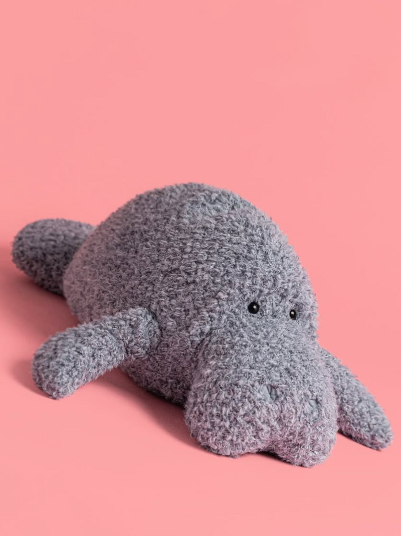 Plush toy manatee on a pink background