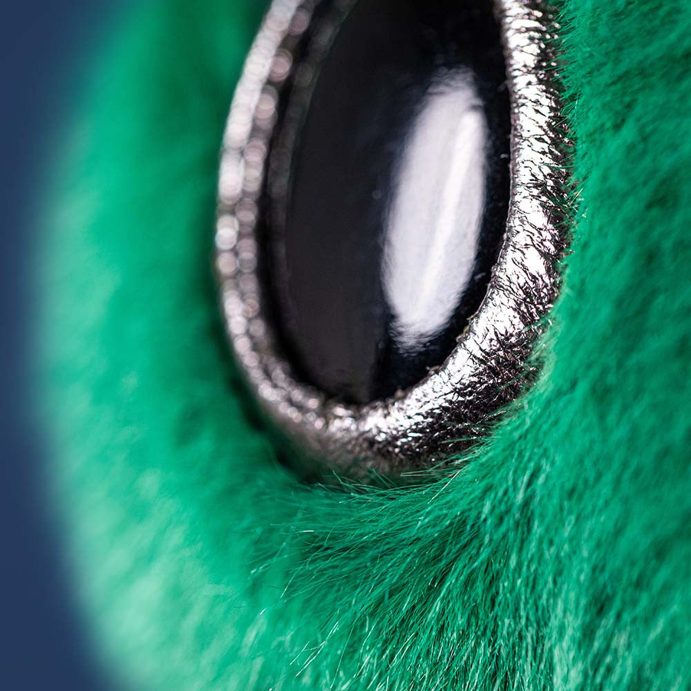 Close-up of a metallic object on green fur