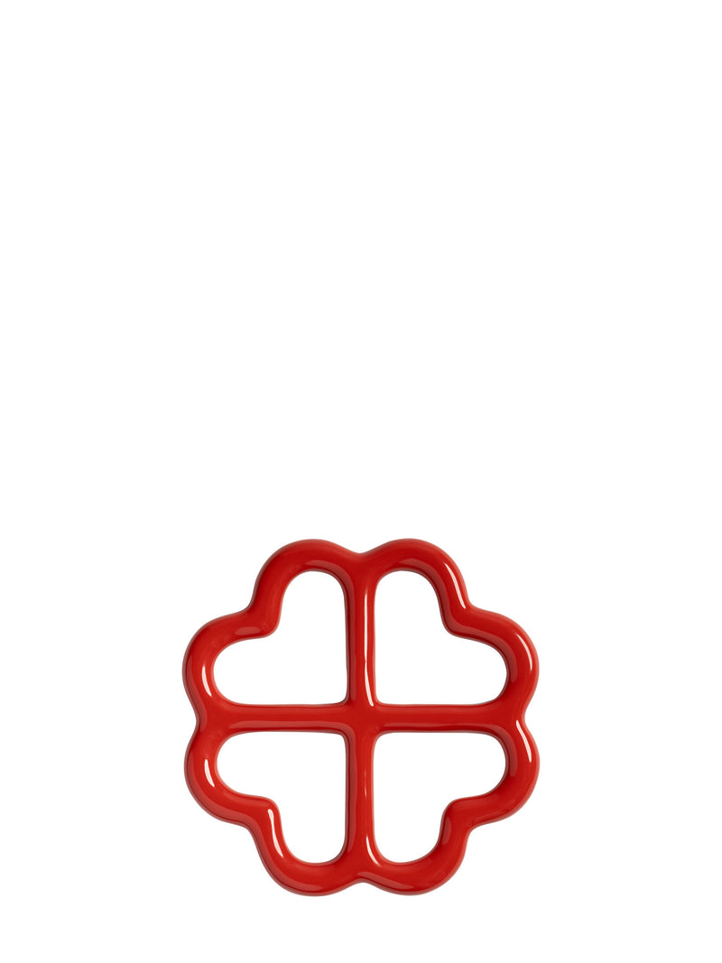 A glossy red four-leaf clover shaped ceramic trivet, shown from upward on a plain white background.
