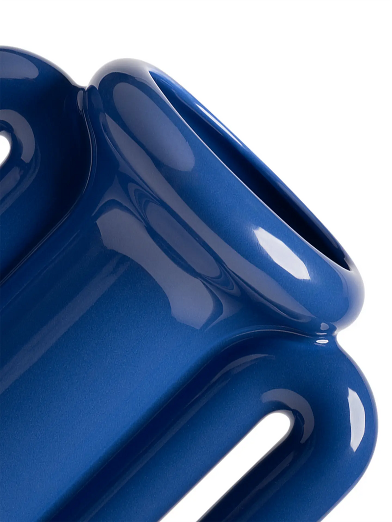 A close-up of a ceramic blue vase or amphora with 2 handles