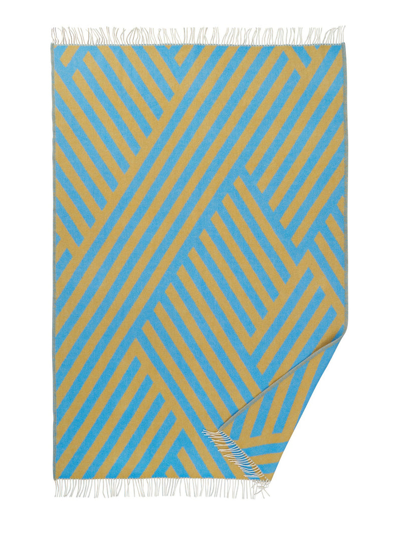 Blue and beige geometric patterned wool throw with fringed edges on a white background