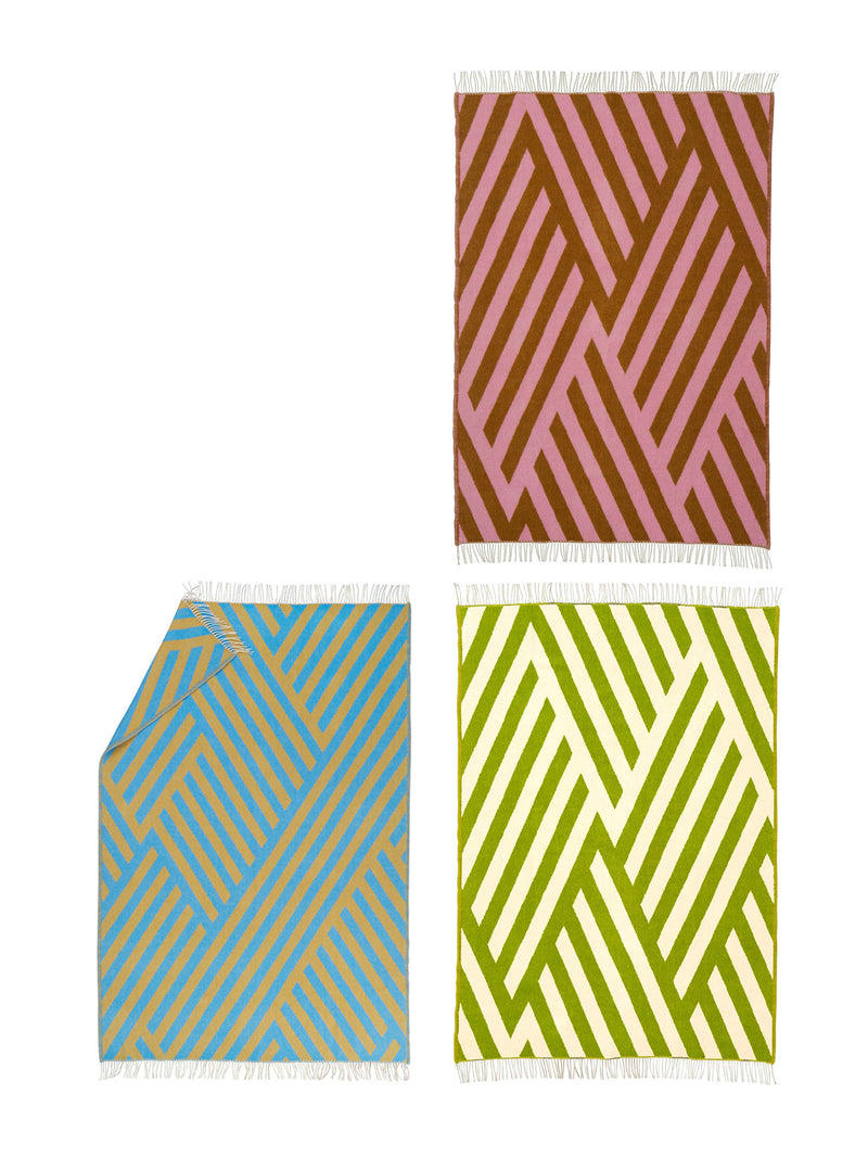 Set of three patterned throws in pink, blue, and green on a white background