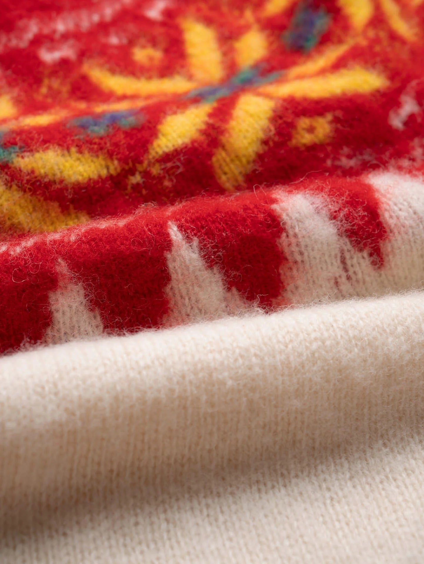 Close-up of a fabric with red, yellow, and white patterns.