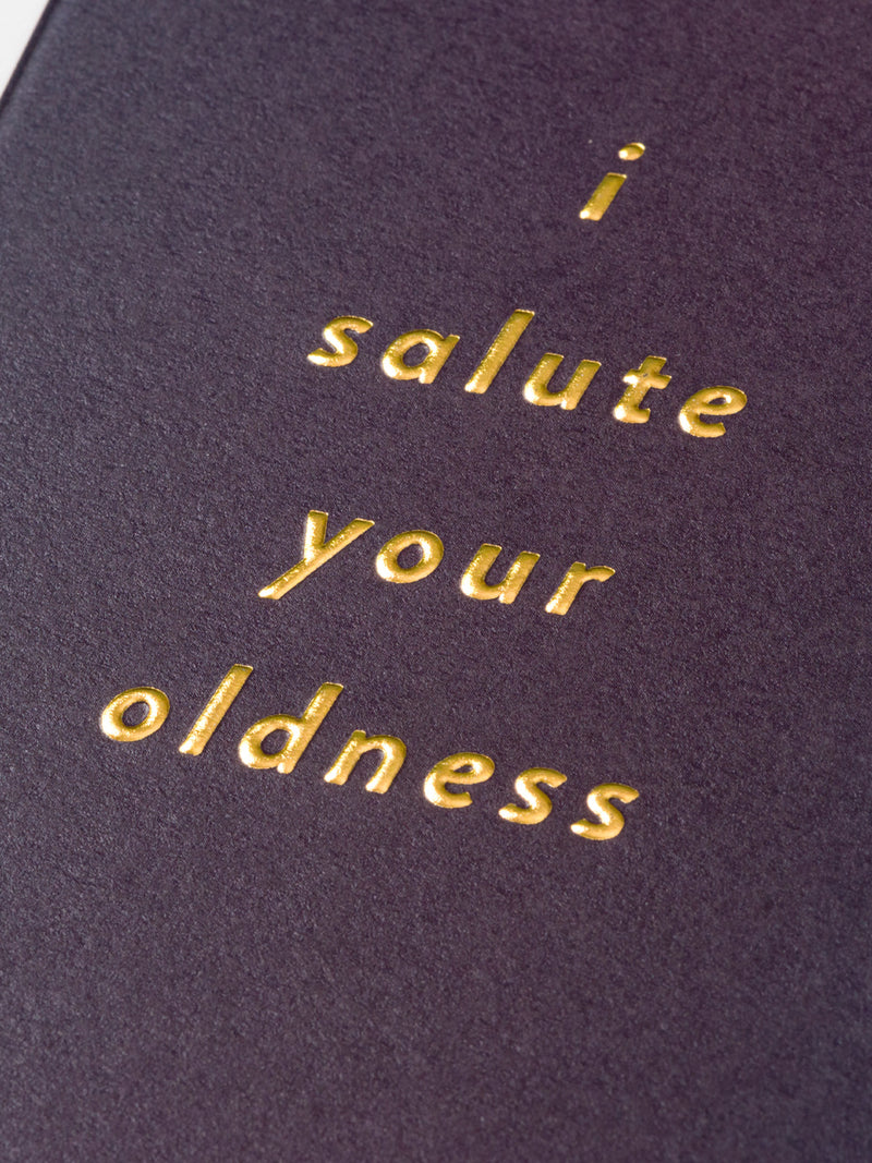 Purple book with gold text 'i salute your oldness' on a dark background