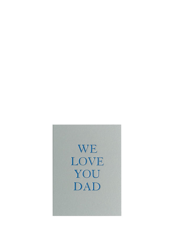 A minimalist greeting card with a light gray background and blue text reading 'WE LOVE YOU DAD' centered on a plain white background.