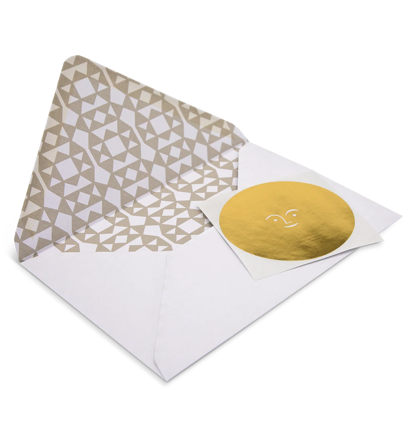 Envelope with geometric pattern and gold circular card on a white background