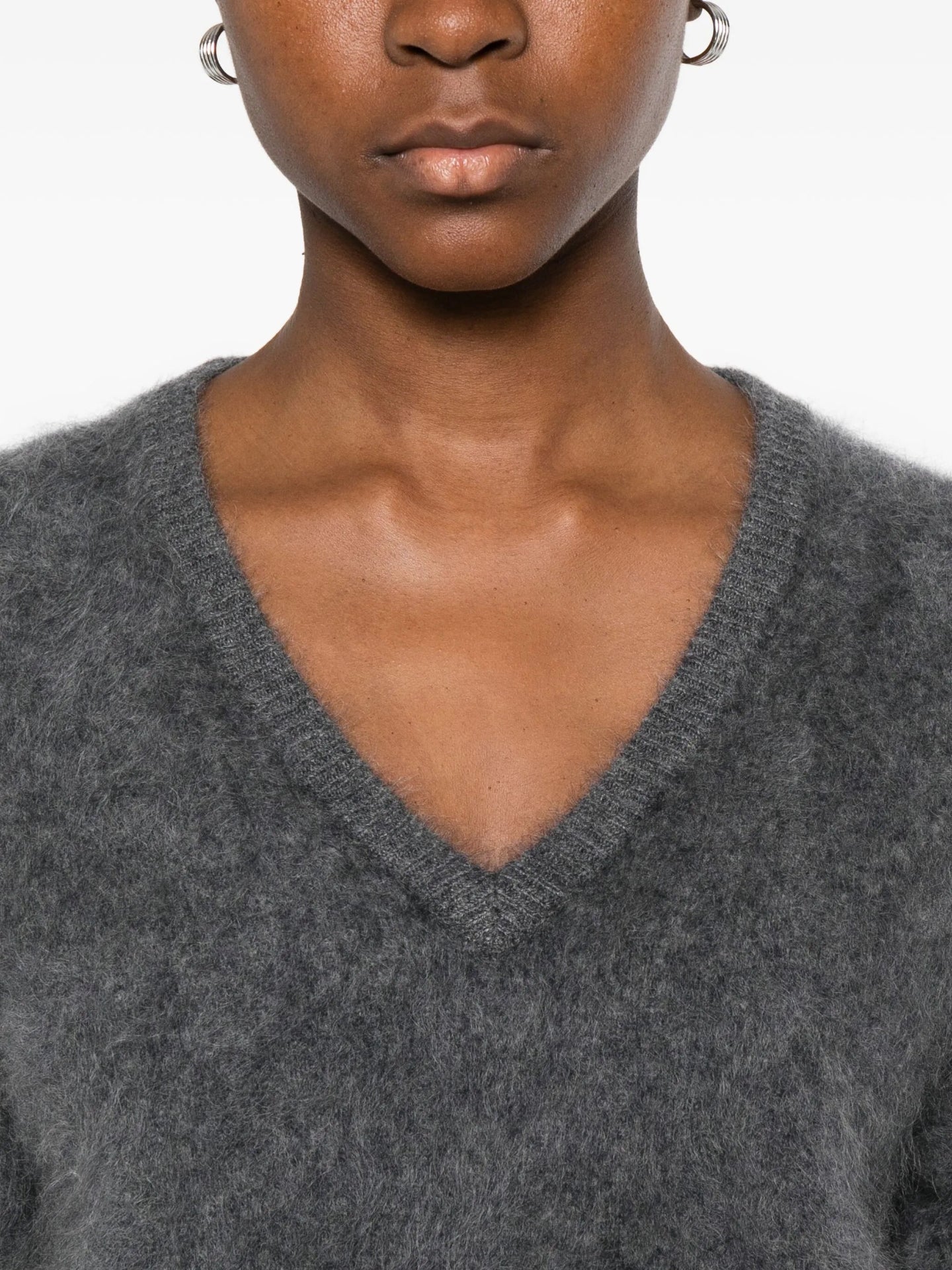 Gray sweater worn by a person on a white background