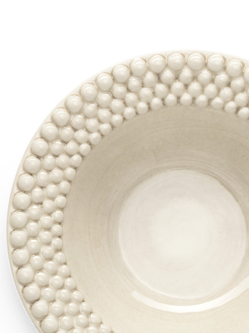 White ceramic plate with decorative bubble edge on a white background