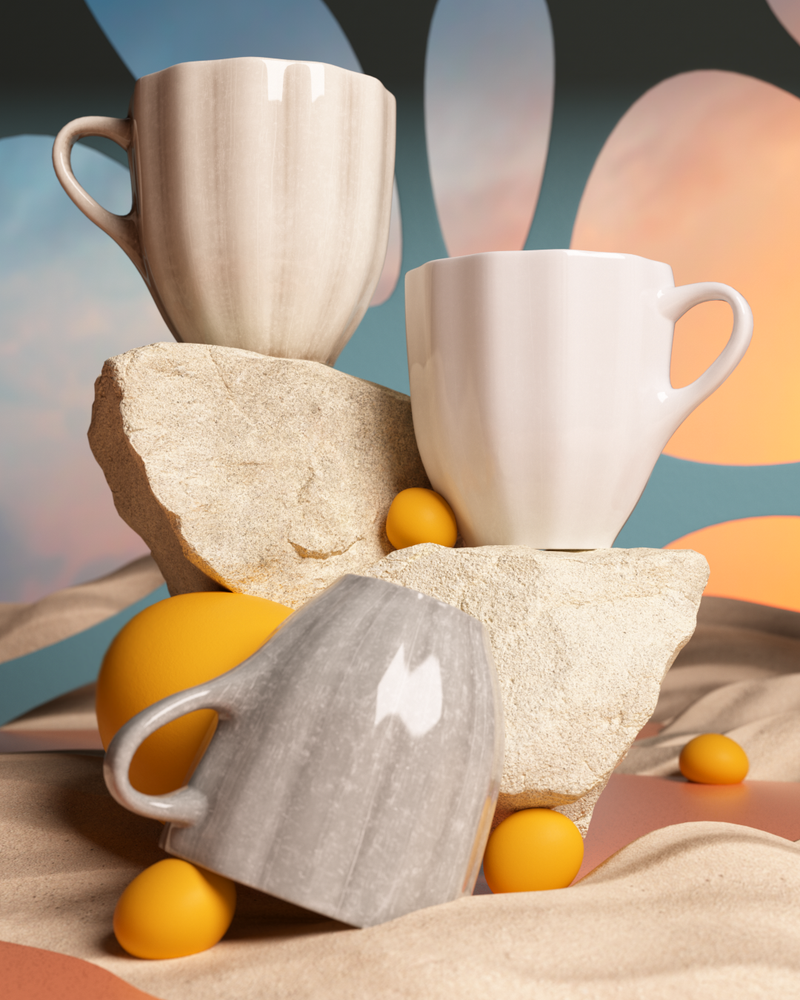 Three ceramic mugs of different colors stacked on a textured surface with yellow spherical objects.