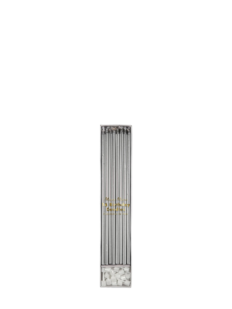 A long, narrow rectangular cardbooard box with multiple silver candles inside, shown on a plain white background. The lower section contains small white cake candle holders for the candles, and there is a small gold logo or emblem near the center.