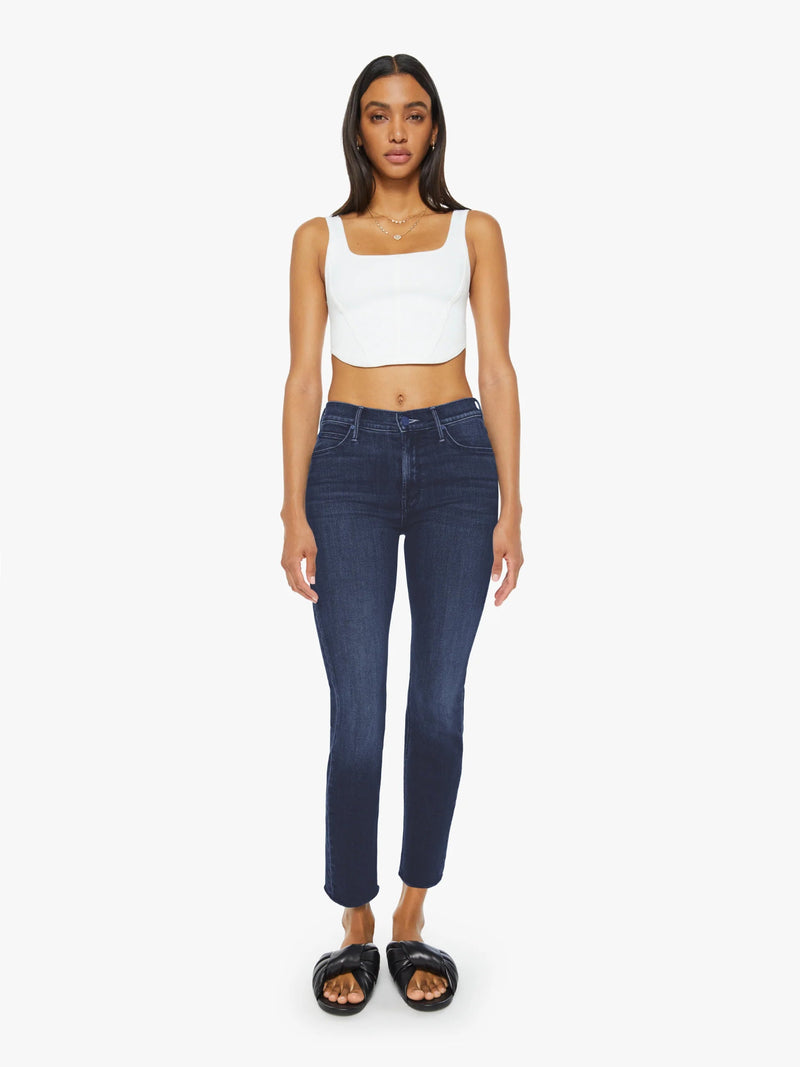 Woman wearing dark blue jeans and a white top on a white background