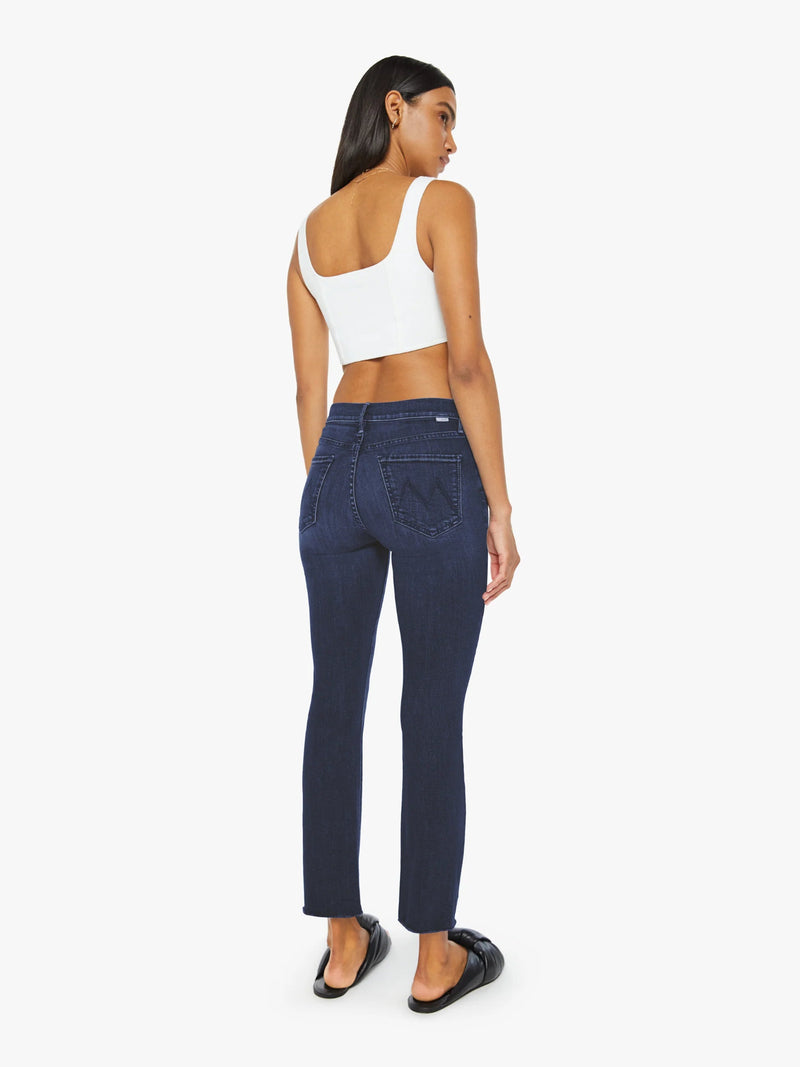 Woman wearing dark blue jeans and a white top on a white background