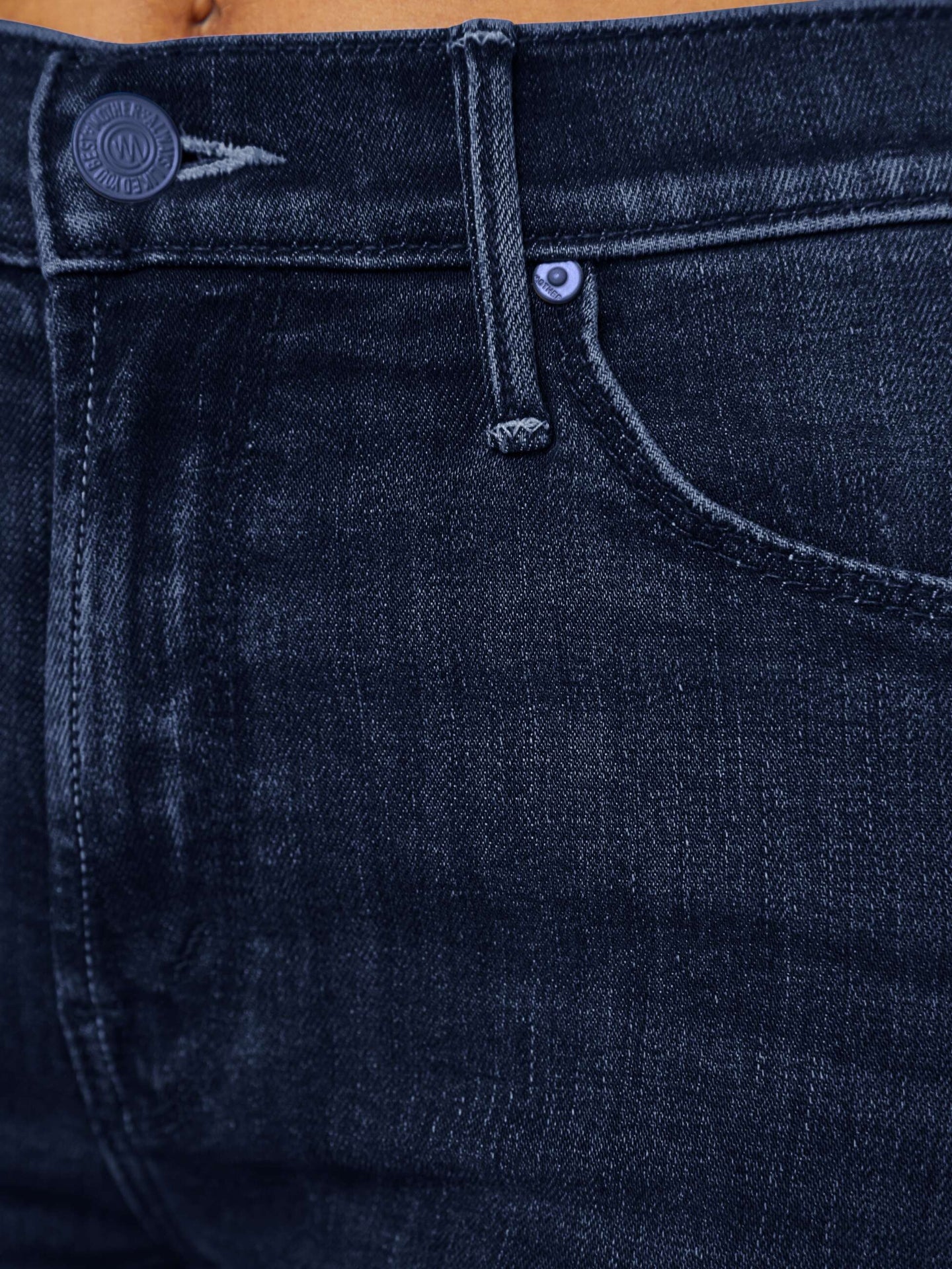 Close-up of dark blue jeans with a brand logo on the pocket.