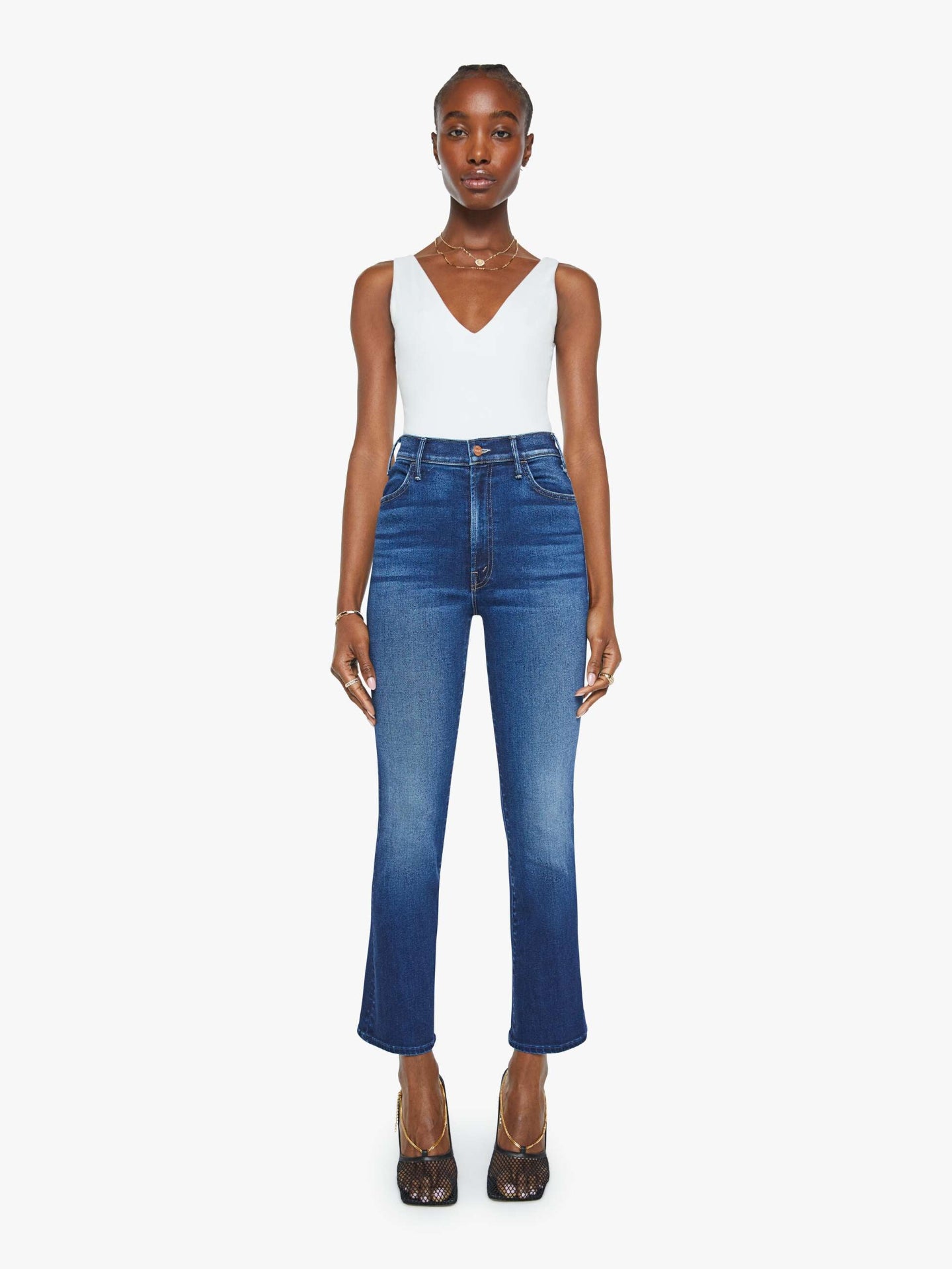 Woman wearing a white top and blue jeans on a white background