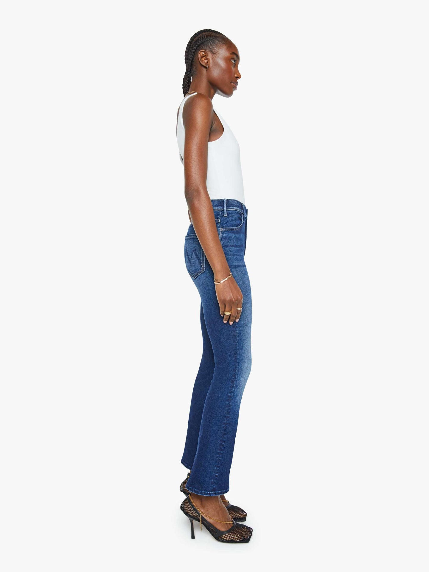 Woman wearing blue jeans and a white top on a white background