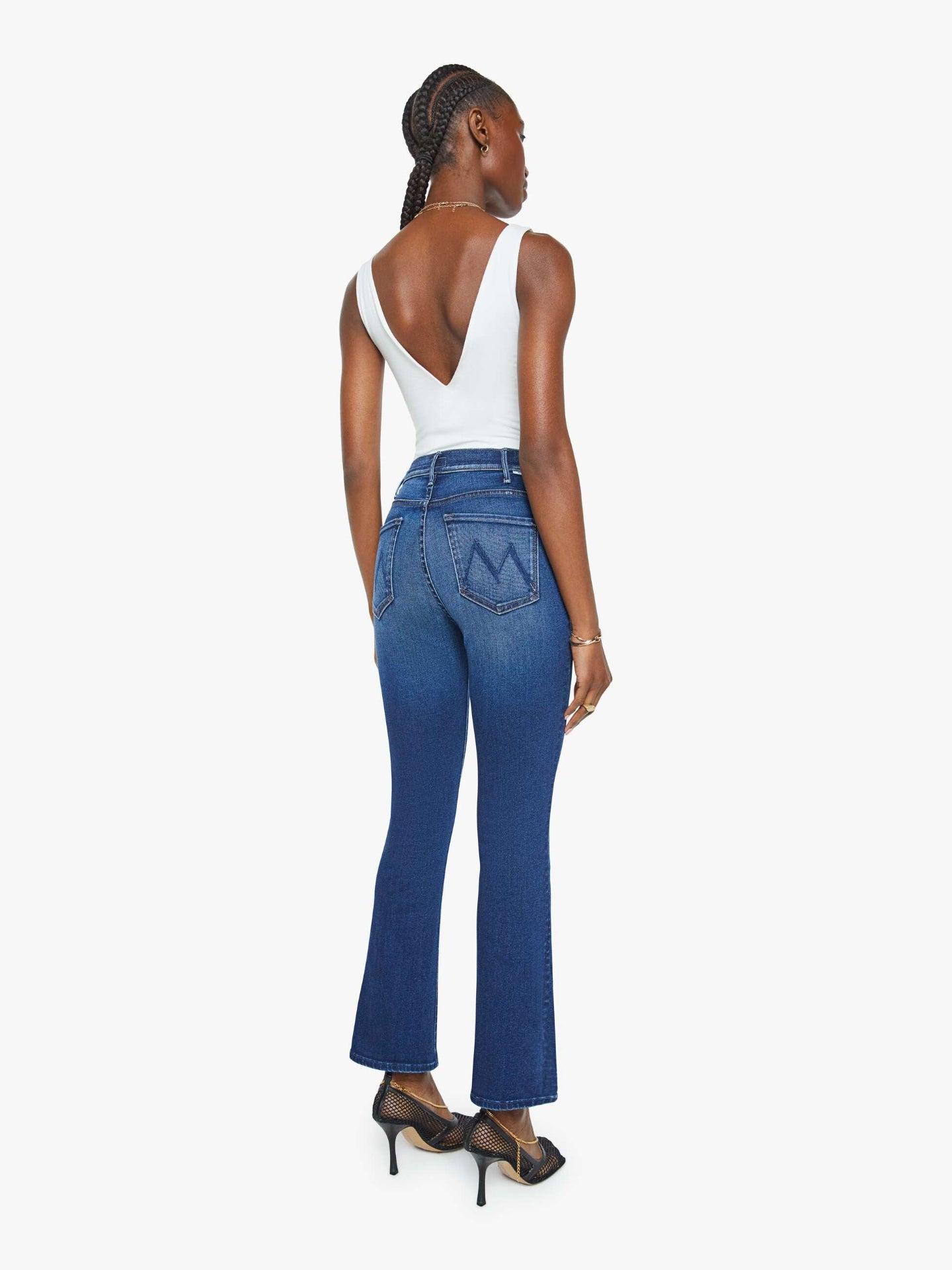 Woman wearing blue jeans and a white top on a white background