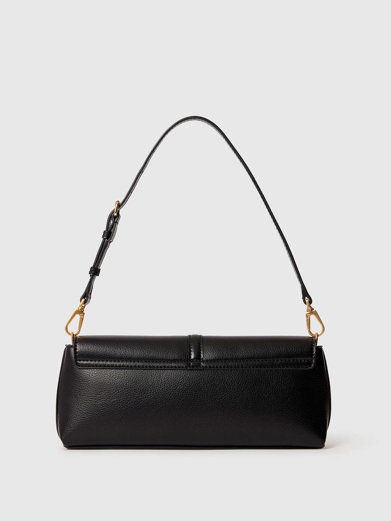 The backside of a black pebbled vegan leather shoulder bag with a long thin strap and gold-tone hardware, shown against a light gray background.