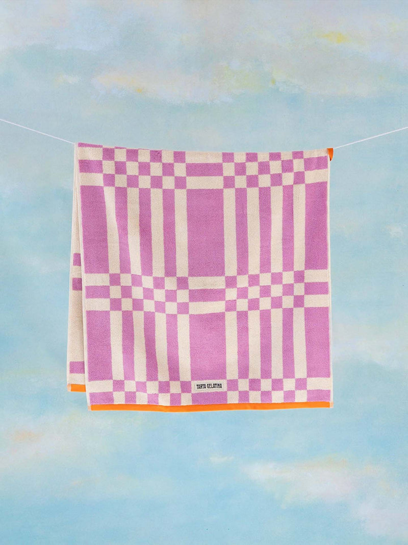 Checkered towel with pink and white pattern on a blue background