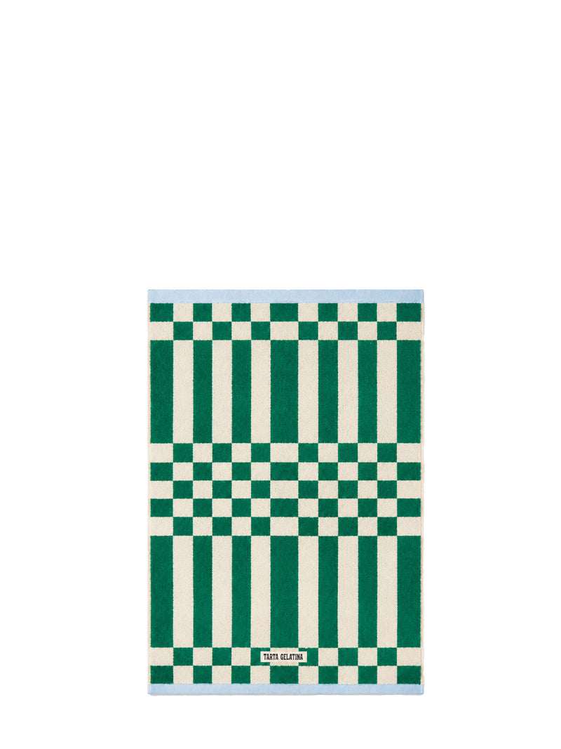 A rectangular terry hand towel with a geometric pattern of green and off-white vertical stripes and checkerboard sections, and a light blue border, shown on a plain white background.