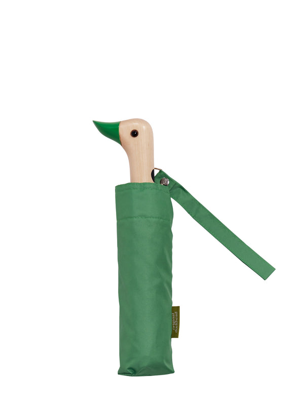 A green umbrella in a matching green fabric sleeve, featuring a duck-shaped wooden handle with a green beak and a small hanging brand tag, shown on a plain white background.