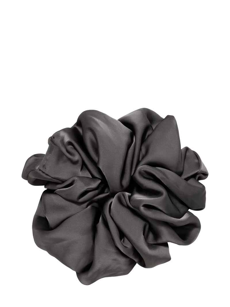 A single dark gray satin or silk scrunchie, shown from a top-down view with soft folds and a subtle sheen, isolated on a solid white background.