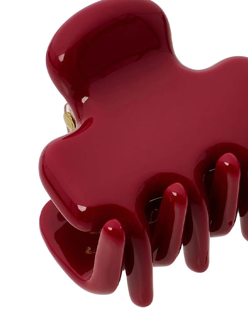 A glossy deep red hair claw clip shown in a close-up studio shot against a white background.