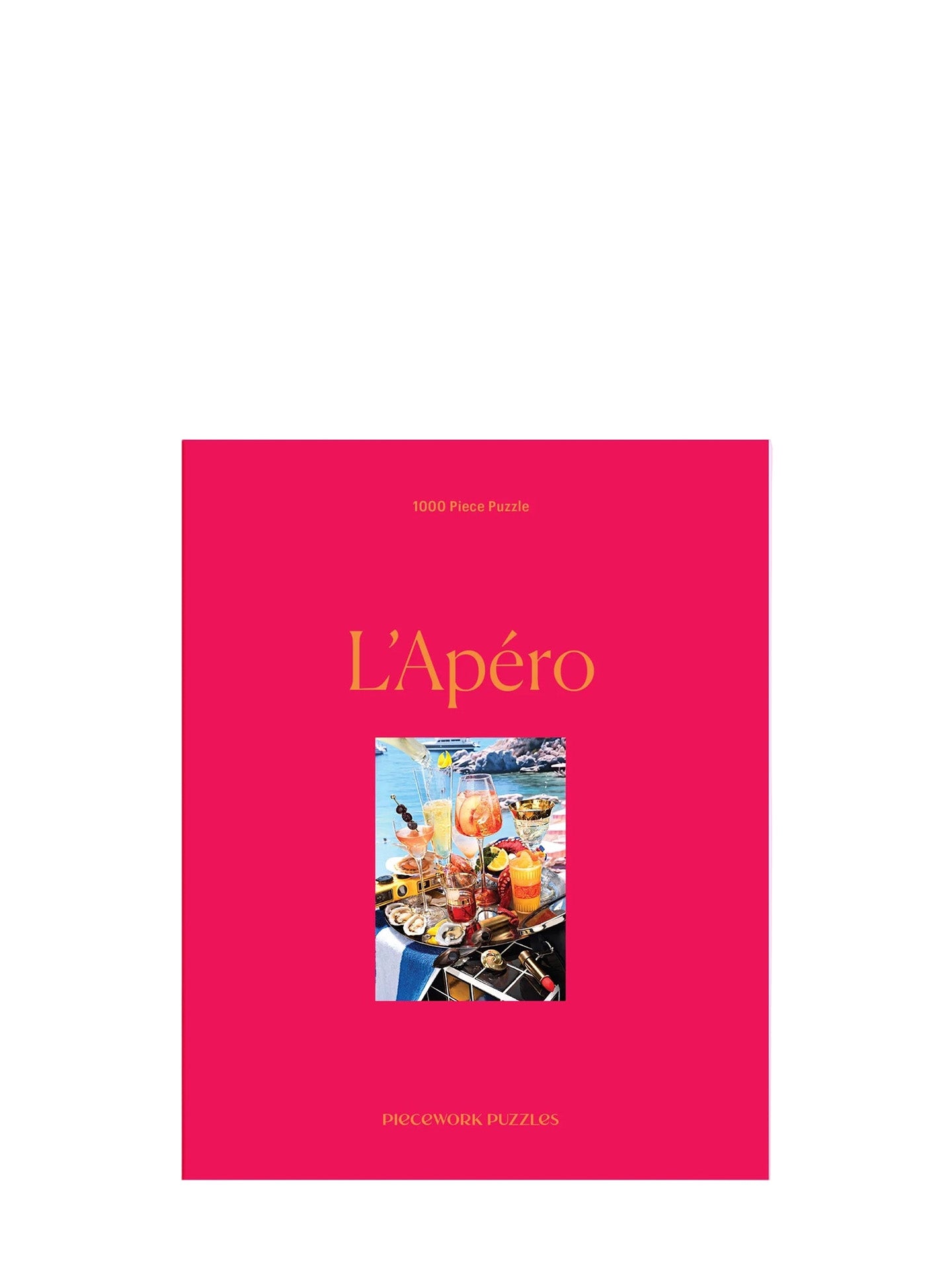 Puzzle L'Apéro by Piecework puzzles has a bright pink box and with 1000 pieces it creates the image of table full of aperatifs on a Mediterraen sea coast.