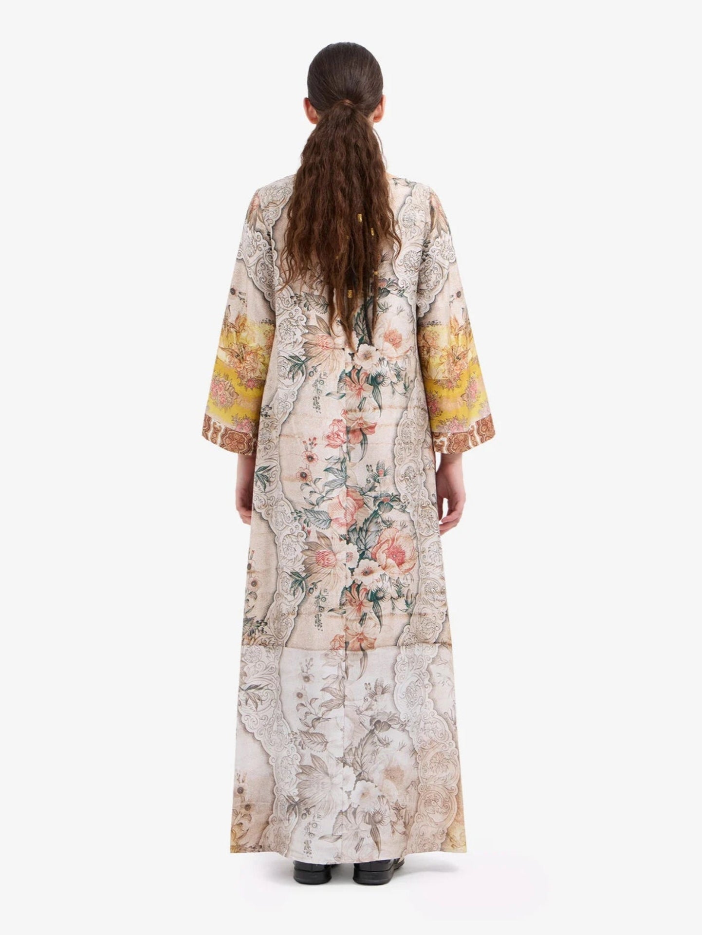 Woman wearing a floral kimono-style dress on a white background