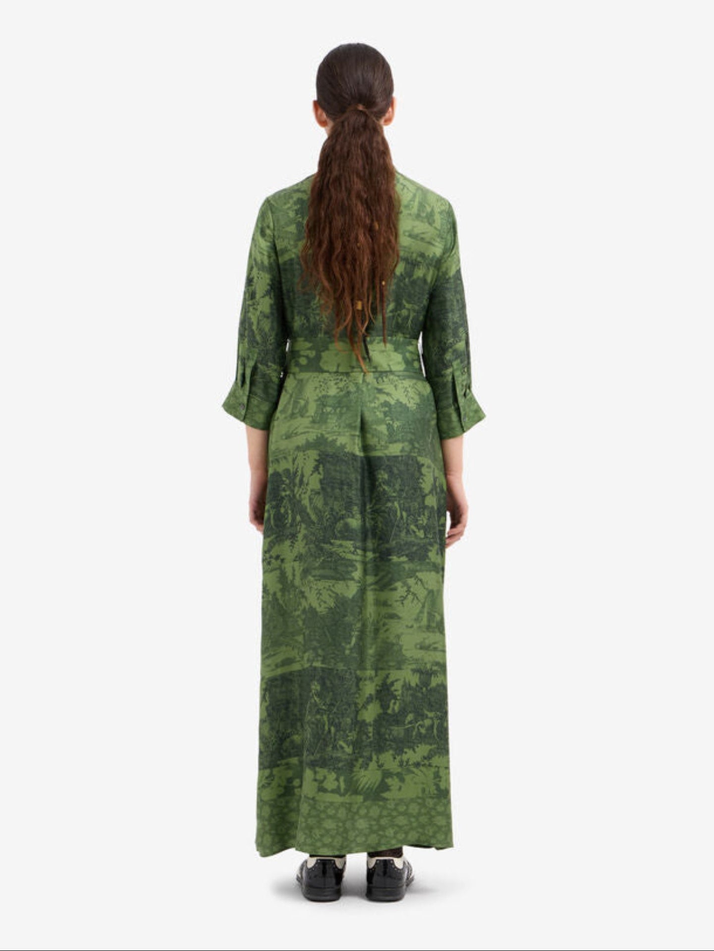 Woman wearing a green patterned dress on a white background