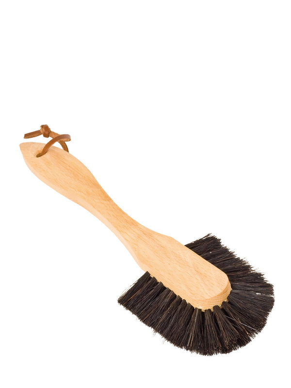A dish brush with a curved handle made of beechwood and dark horsehair bristles.