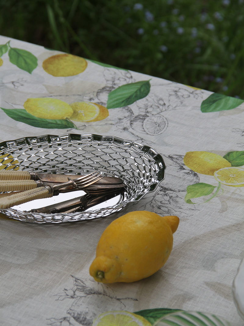 Silver tray with cutlery on a tablecloth with lemon design