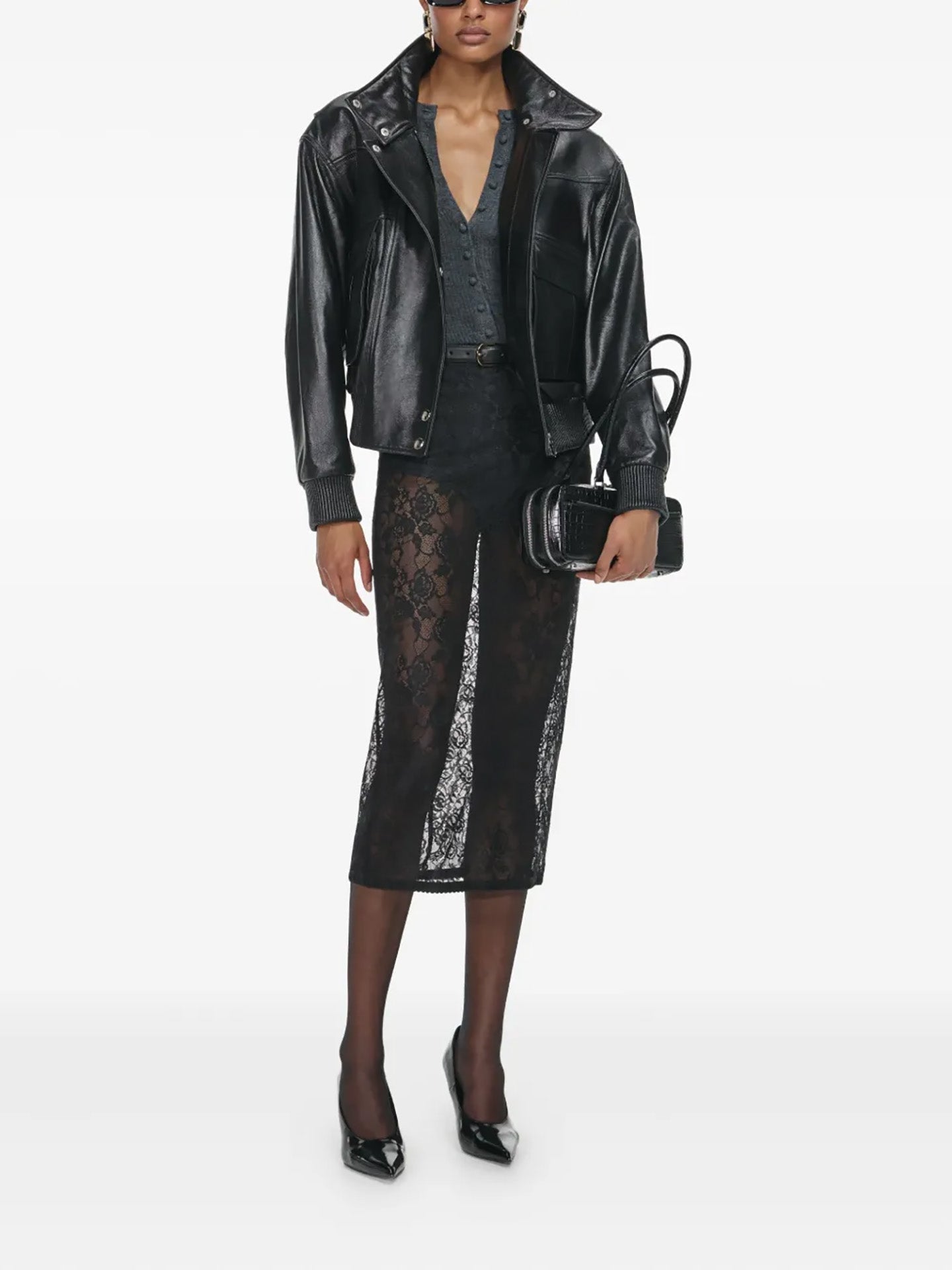 Person wearing a black leather jacket and lace skirt on a white background