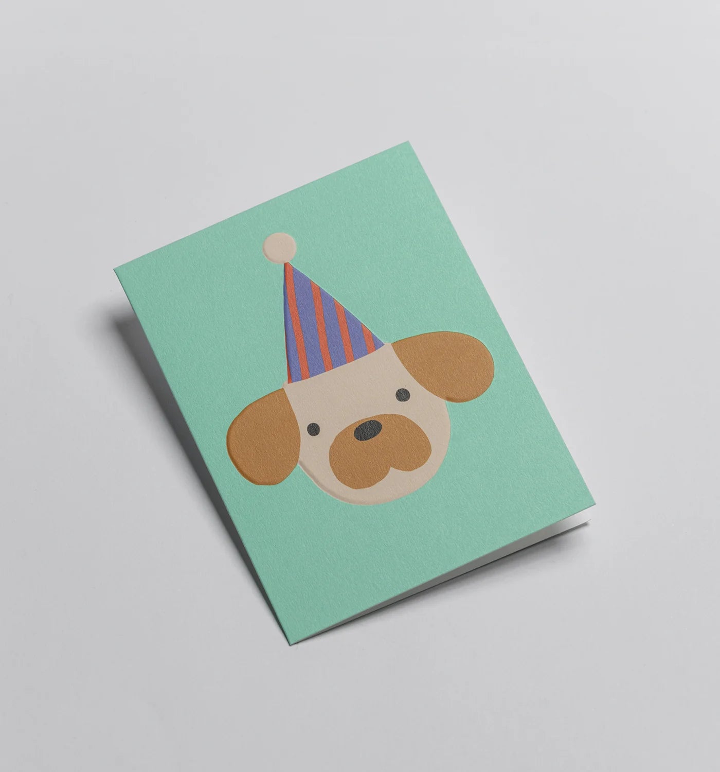 Greetiing card with a dog wearing a party hat on a light gray background