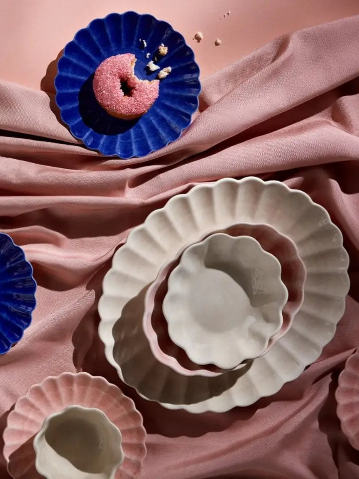 Decorative ceramic plates on a pink fabric background