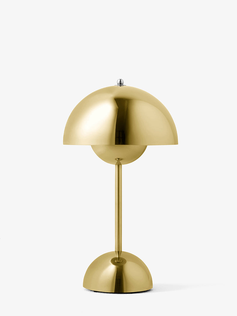 A modern mushroom-shaped table lamp in polished brass, featuring a dome-shaped shade, a central globe bulb, and a matching dome base on a clean white background.