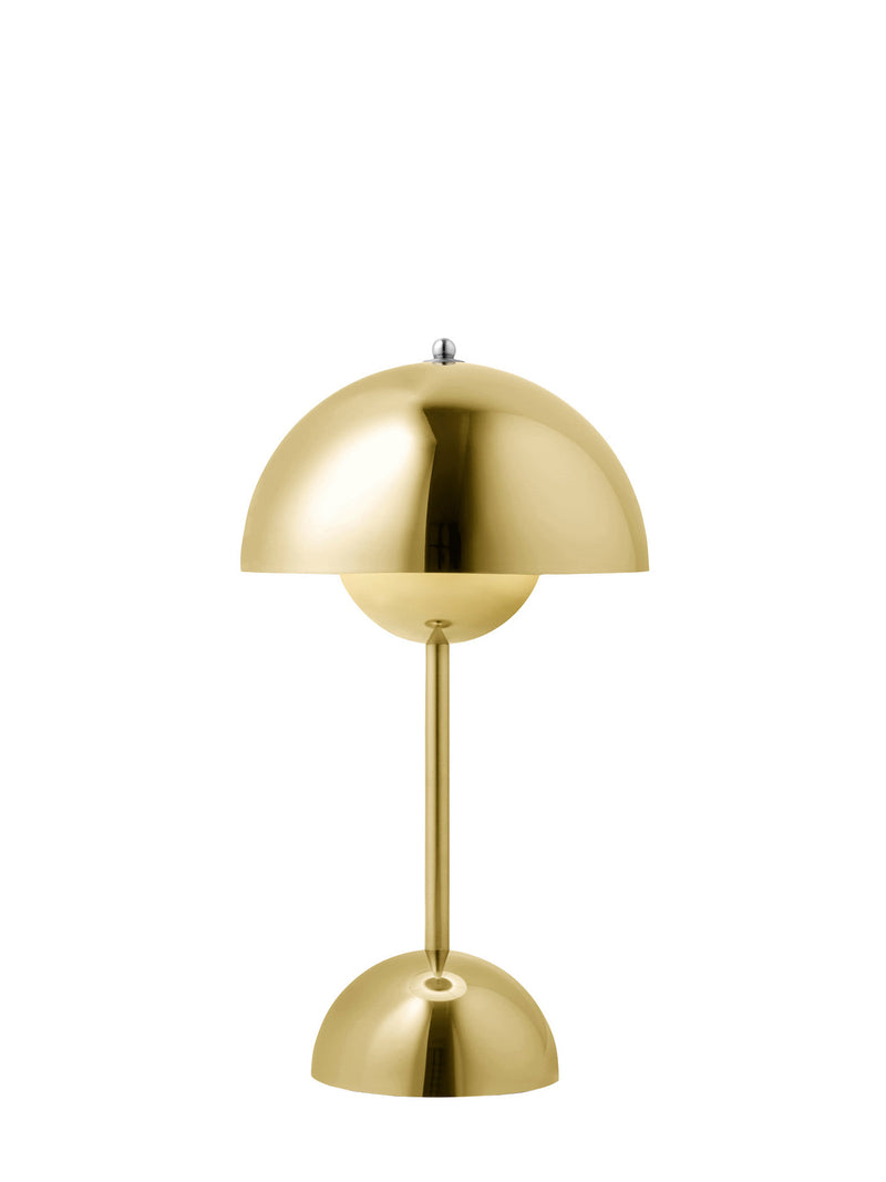 A modern mushroom-shaped table lamp in polished brass, featuring a dome-shaped shade, a slender central stem, and a matching dome base, lit up and shown against a solid white background.