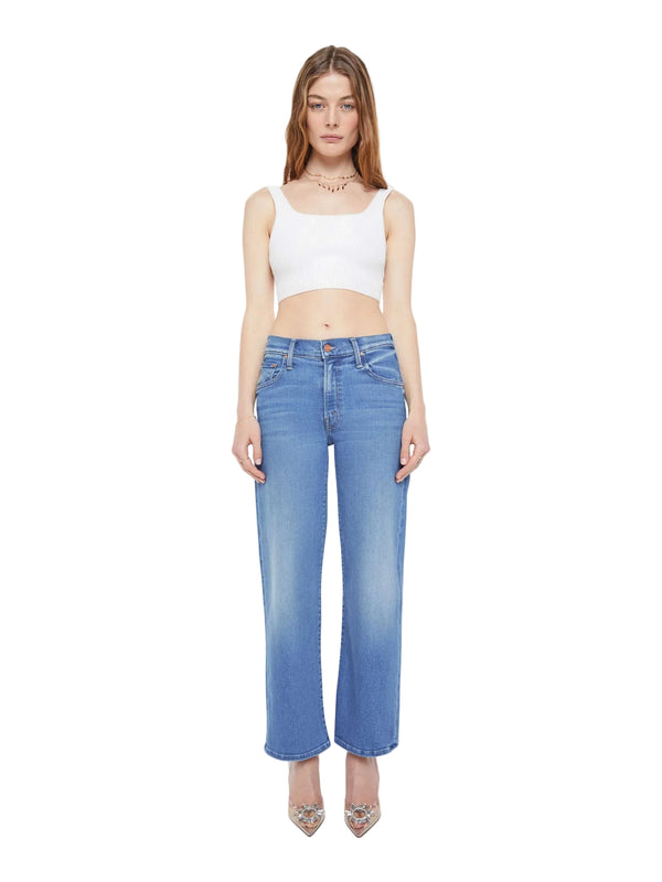 Woman wearing a white crop top and blue jeans on a white background