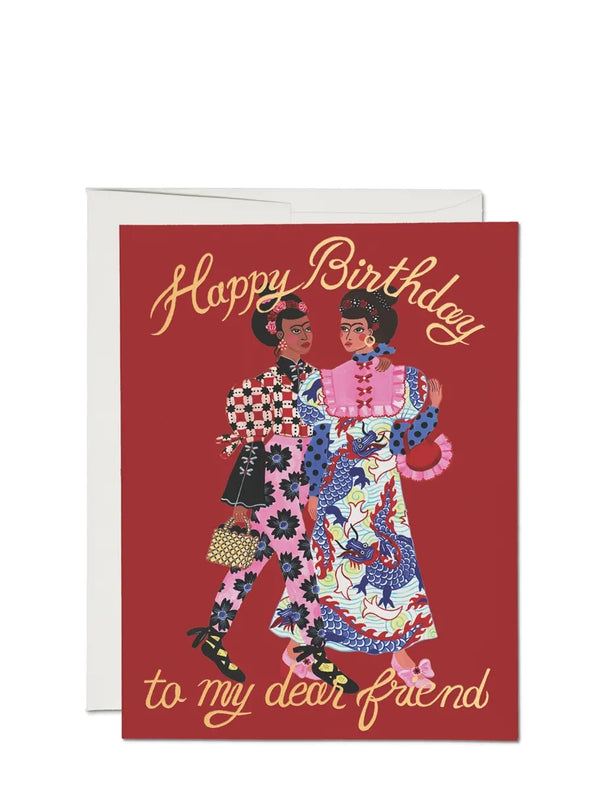 Illustrated birthday card with the phrase 'Happy Birthday to My Dear Friend!' featuring a colorful cartoon of two people dancing. The card is red with gold foil lettering.