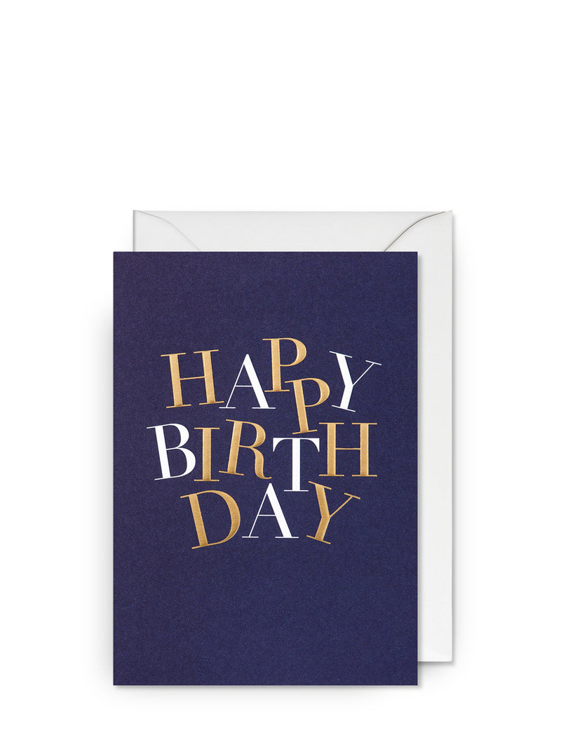 A navy blue birthday greeting card with 'HAPPY BIRTHDAY' text in a playful, jittery font printed in white and gold foil. A white envelope is included.