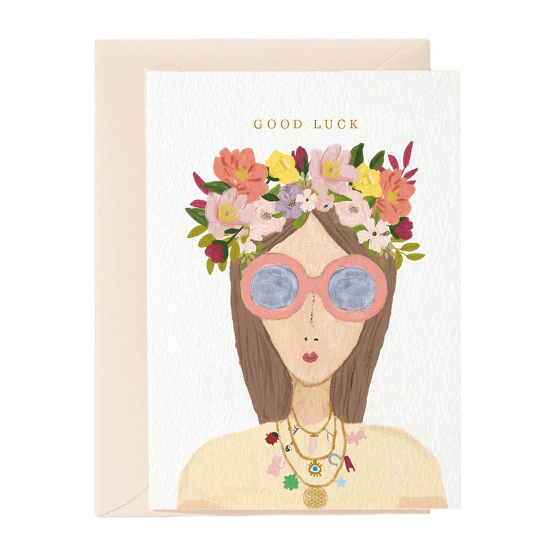 Greeting card with illustration of a woman wearing sunglasses and a floral headband, with 'Good Luck' text.