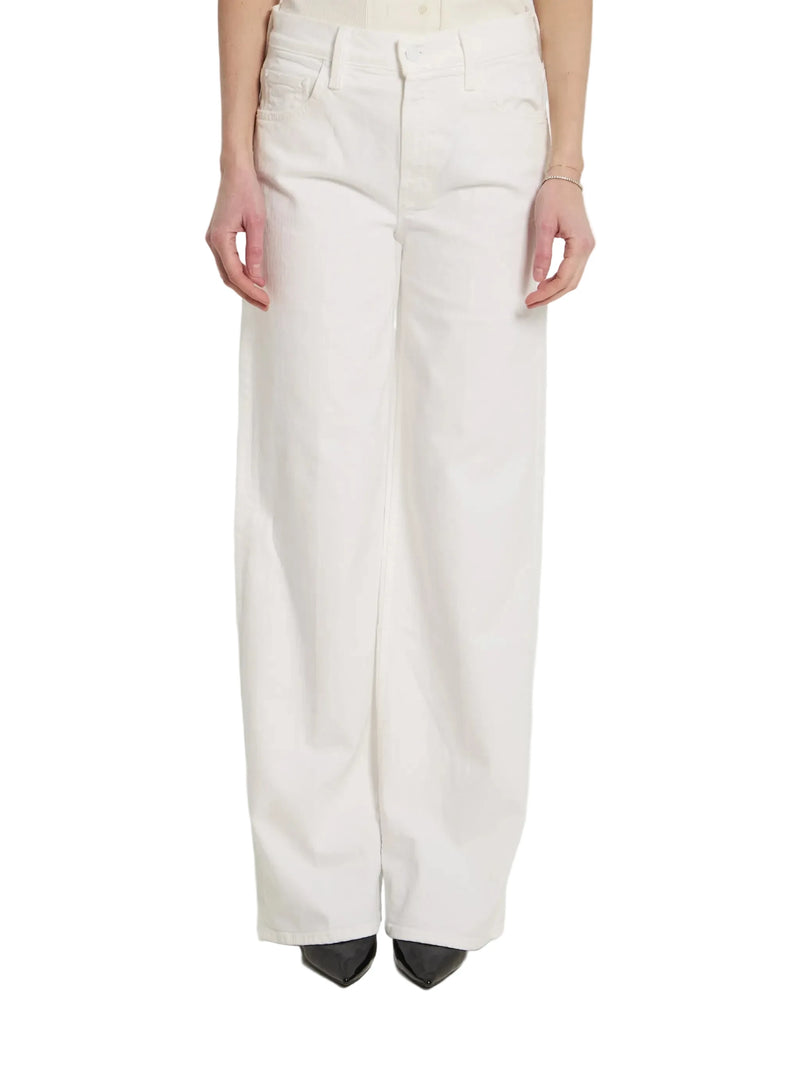 A model from the waist down wearing off-white wide-leg trousers and black pointed-toe heels, standing against a plain white studio background.