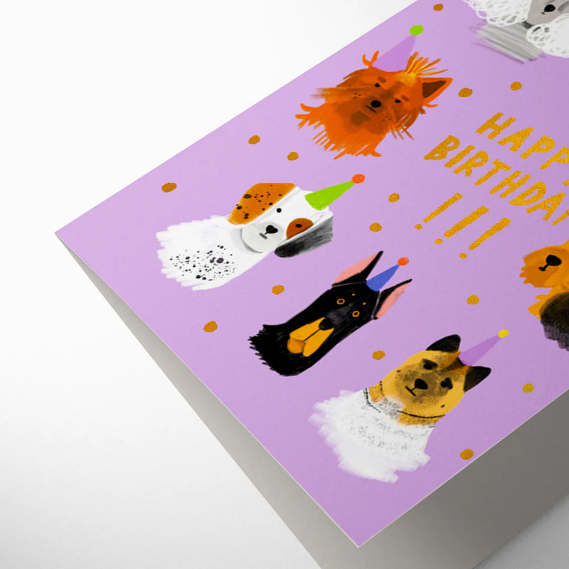 Card with cartoon dog illustrations and 'Happy Birthday' text on a purple background