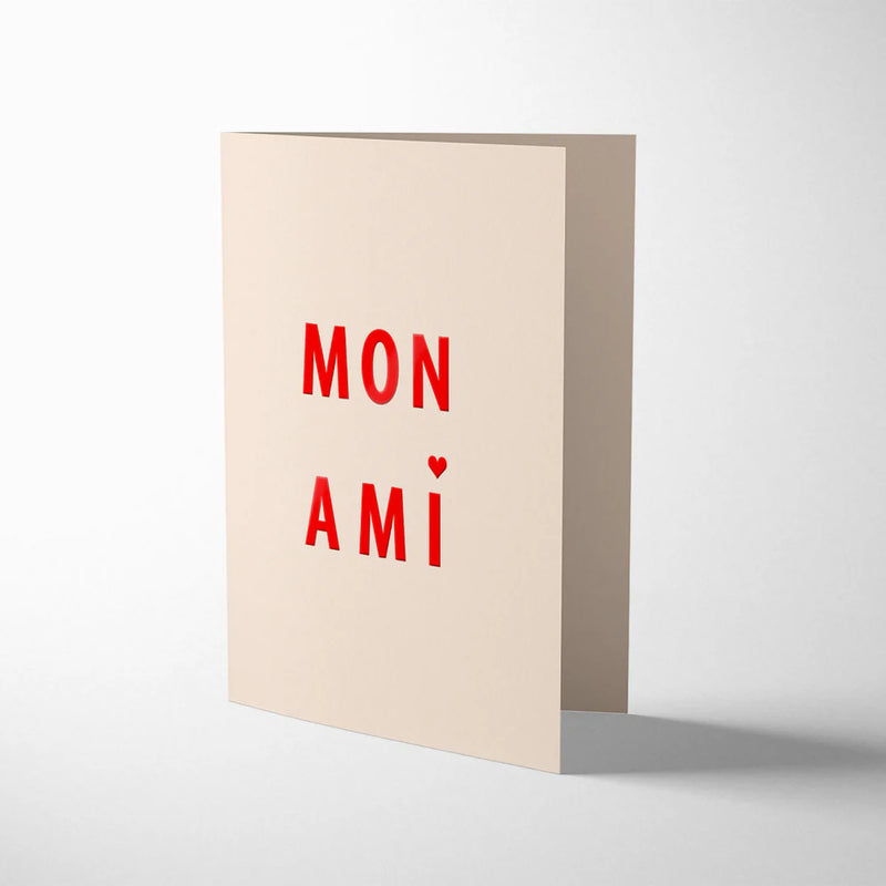 Beige greeting card with red text 'MON AMI' on a white background