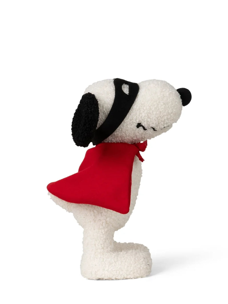 A plush Snoopy figure wearing a red cape and black mask, posed in profile against a clean white background.