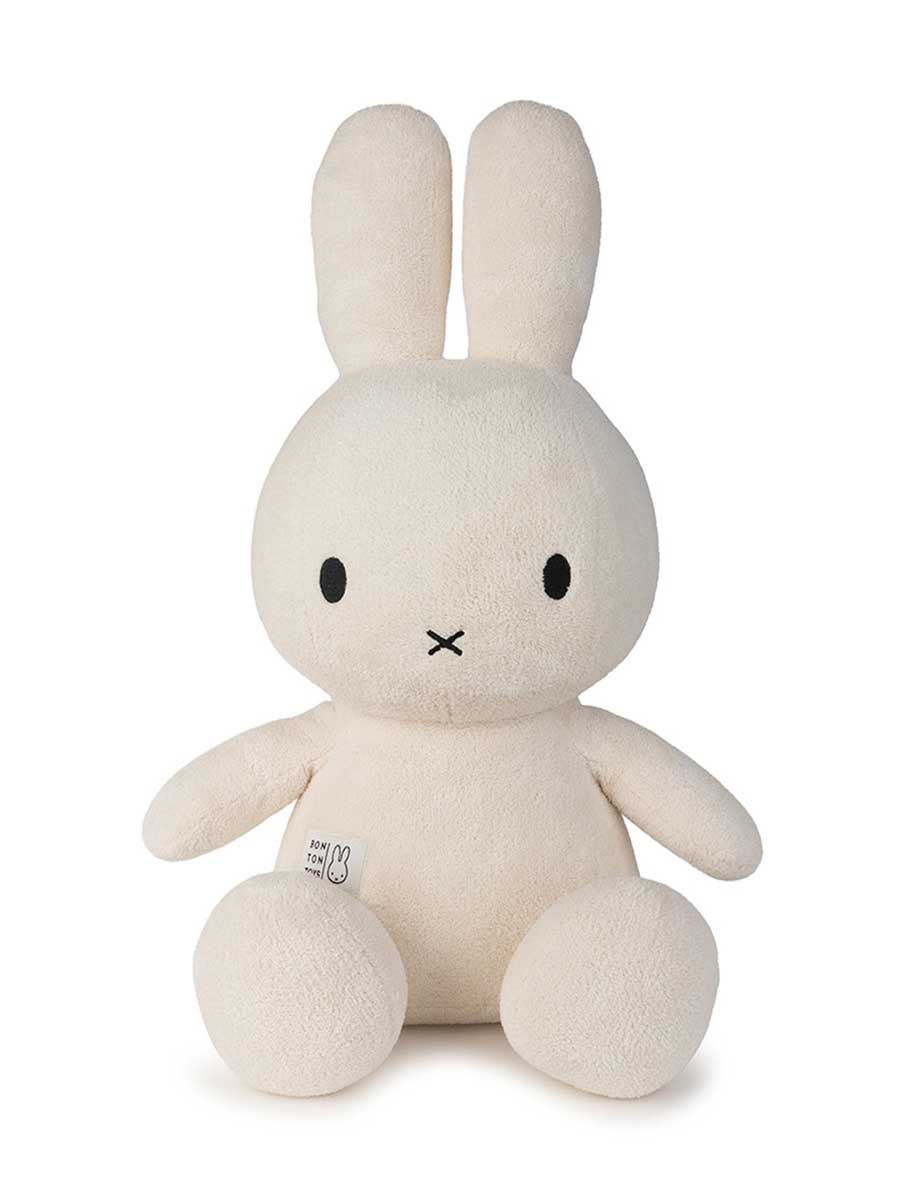 White plush bunny toy Miffy with black eyes and mouth on a white background