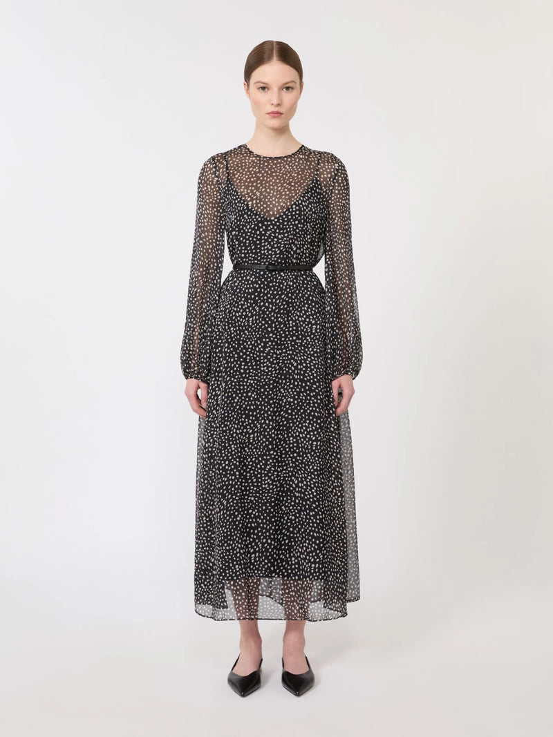 Woman wearing a black and white patterned dress on a white background