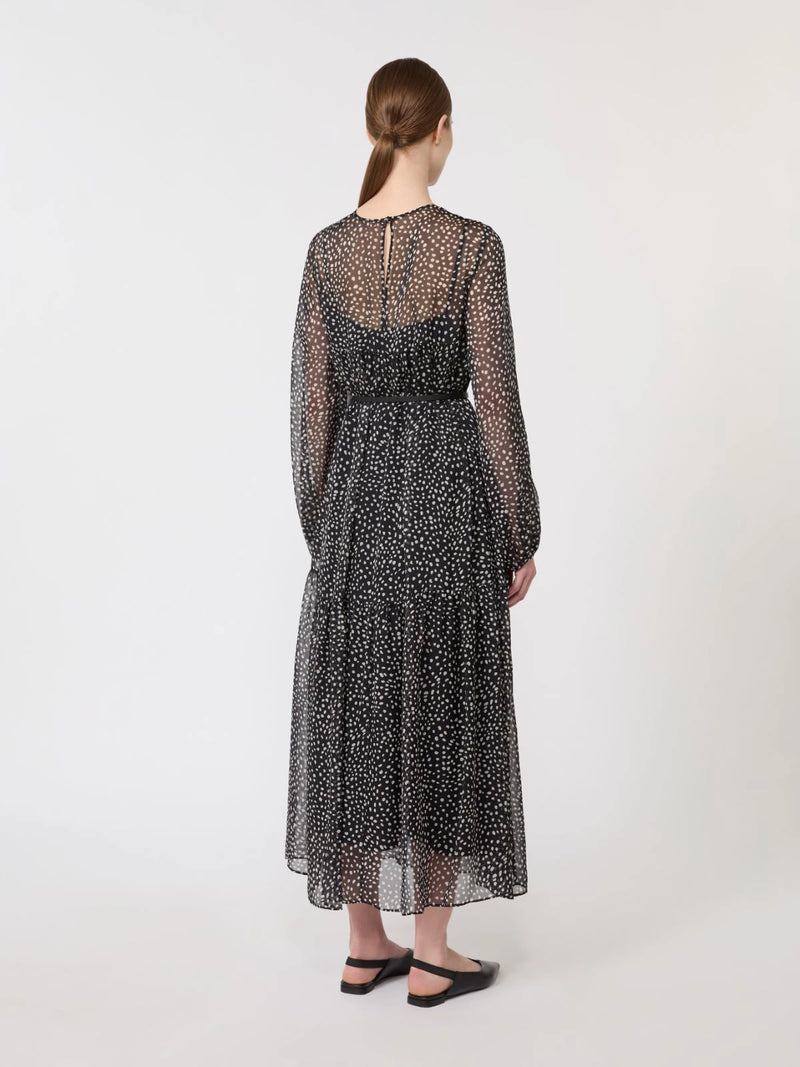 Woman wearing a black polka dot light dress on a white background